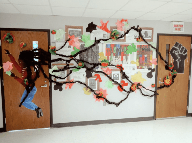 Two doors connected in the middle with yarn representing a Black woman's hair attaching to a BLM raised fist