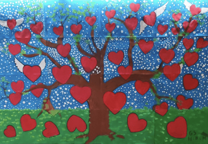 Bulletin board with cutout of a tree with hearts on the branches- Valentine's Day Bulletin Boards