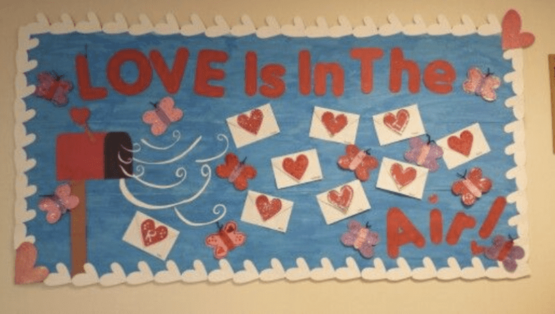 Bulletin board with cutouts of letters with hearts on them and words LOVE is in the air!- Valentine's Day Bulletin Boards