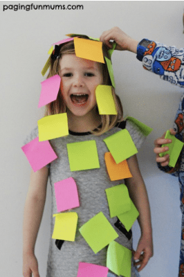 Kid getting covered in sticky notes, as an example of minute to win it games for kids