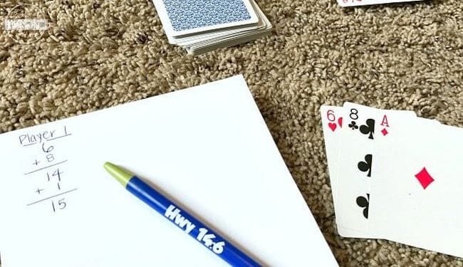 Playing cards next to a notepad and pen (Second Grade Math Games)