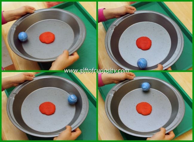 silver pie plate with a smashed circle of red play dough in the center and a blue rubber ball along the border of the pan