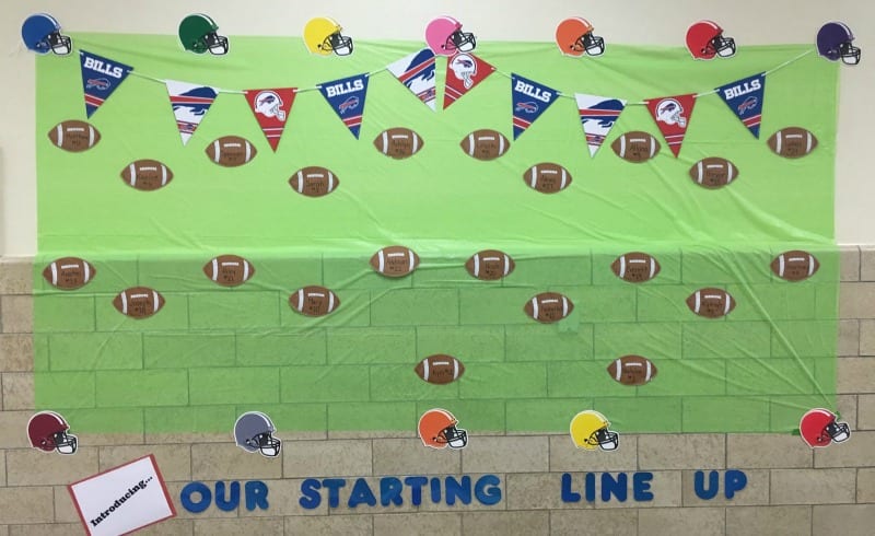 Football themed bulletin board with helmets, footballs, and pennants. Text reads Our Starting Lineup.