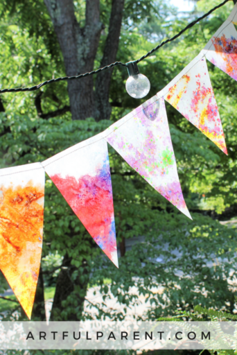 colorful bunting made from wax paper cut into triangular shapes with crayon shavings pressed in between, as an example of summer crafts for kids