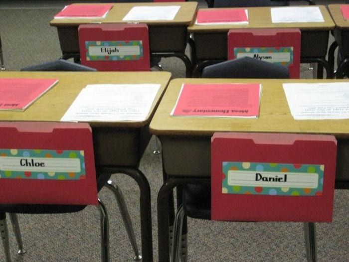 Student desks with red file folders in classroom