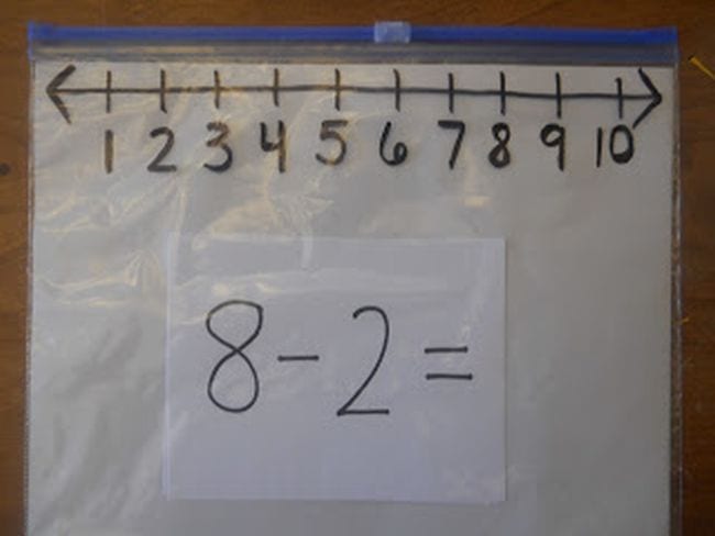 plastic bag with a number line drawn at the top and a card with a subtraction problem below it