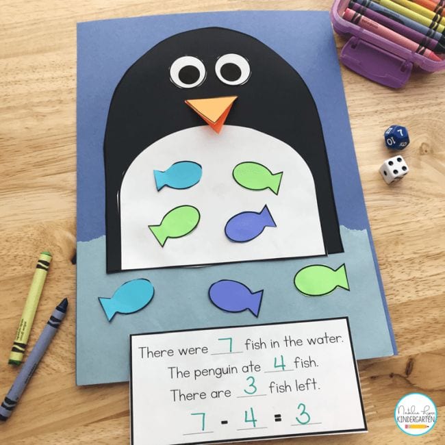 a colorful construction paper penguin with cut out fish on its belly