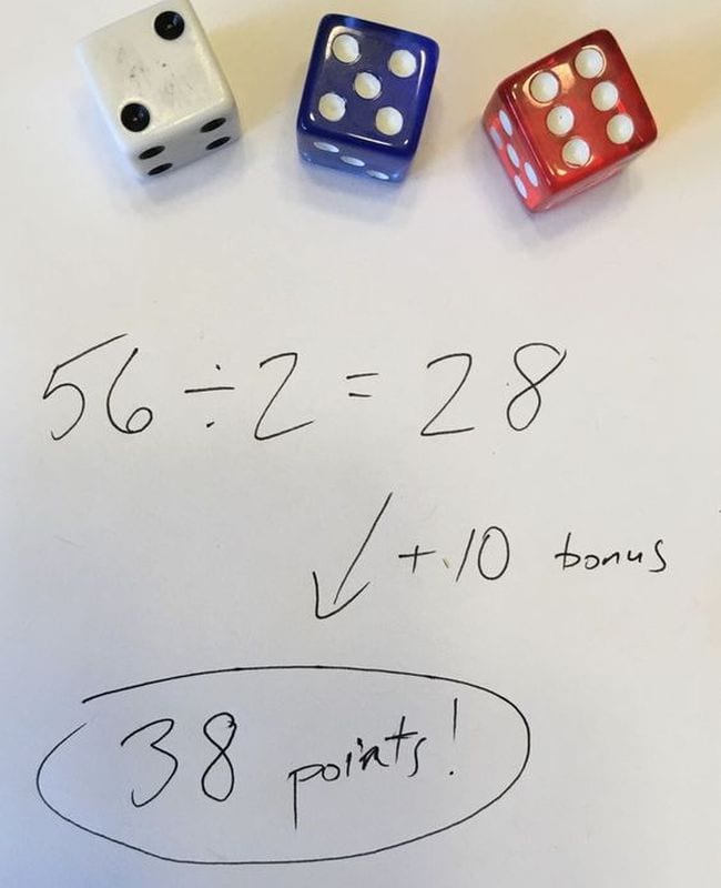 Three dice next to division problem 56 / 2 = 28 + 10 bonus is 38 points!