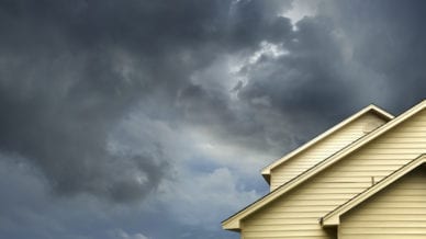A picture of a house with a stormy sky above it.