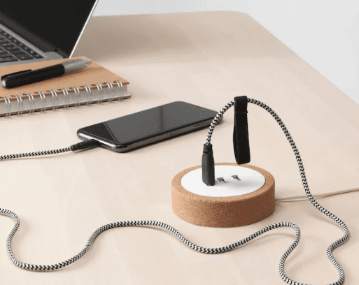 desktop USB charger on a desk with a phone connected to it