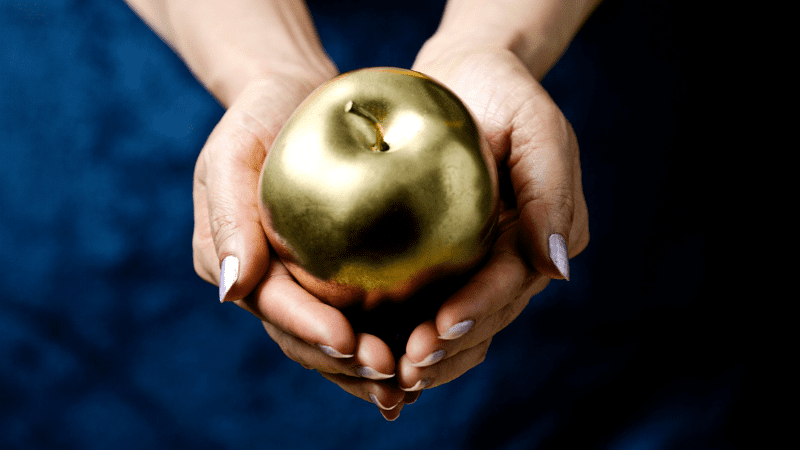 Image of a woman's hands holding a golden apple - Great Greek Myths