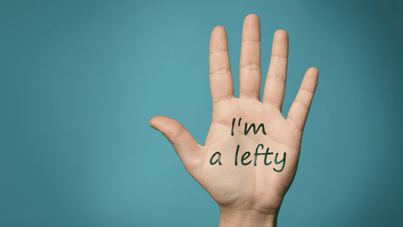 Left hand with "I'm a lefty" written on it in front of blue background