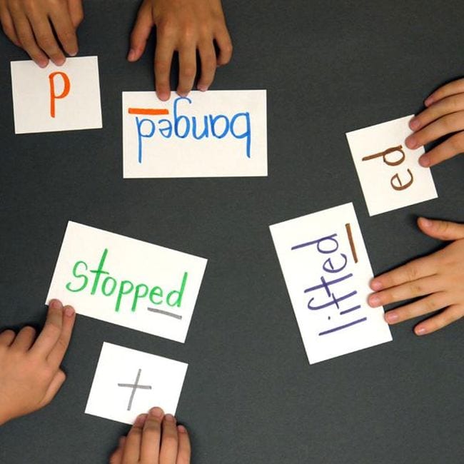 Students matching cards with past tense verbs with the appropriate pronunciation