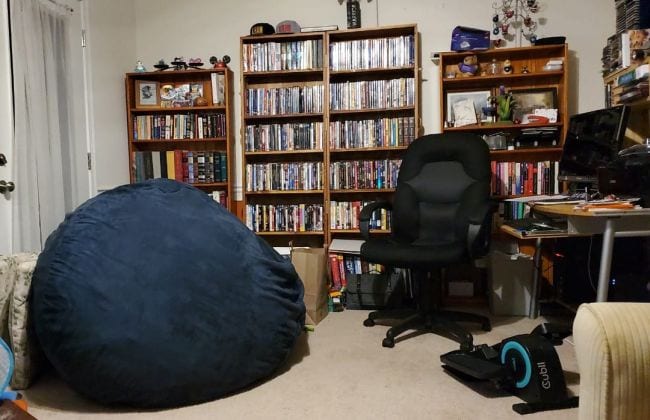 Computer desk and chair in room with bean bag seat and bookcases
