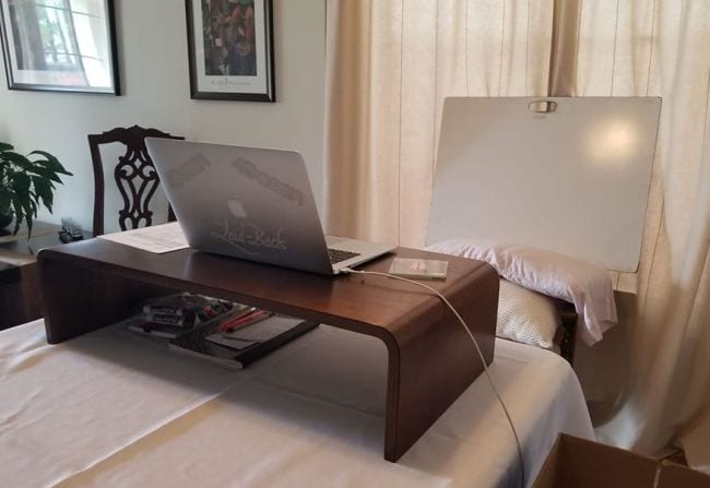 Wood desk used to raise height of laptop for virtual classroom