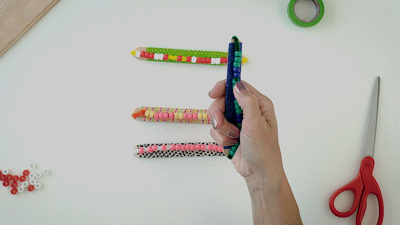 Student playing with a DIY fidget stick made from popsicle stick and beads (Inexpensive Gifts for Students)