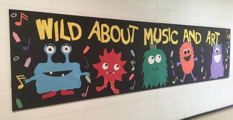 Bulletin board with big monsters reading Wild about music and art. (Back-to-School Bulletin Board Ideas)