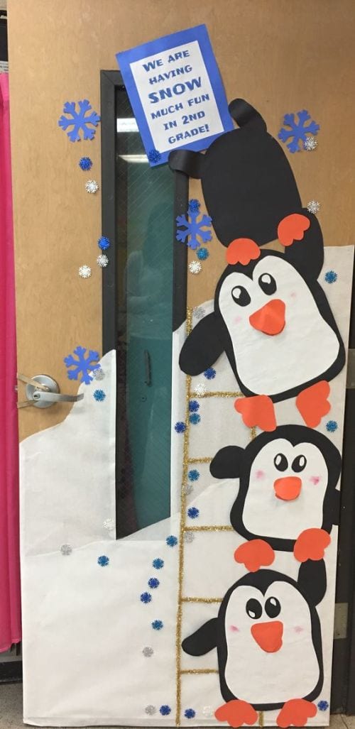 Classroom door decorated with a stack of paper penguins saying We are having snow much fun in 2nd grade
