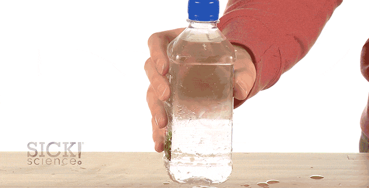 Animated gif of a hand slamming a water bottle on a table, making the water inside freeze instantly