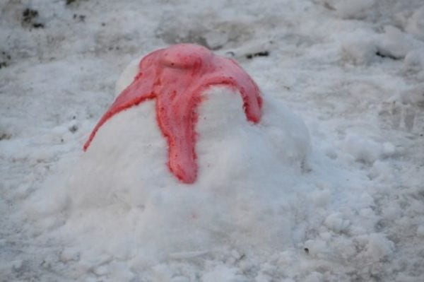 Baking soda volcano with red lava erupting out of a pile of snow