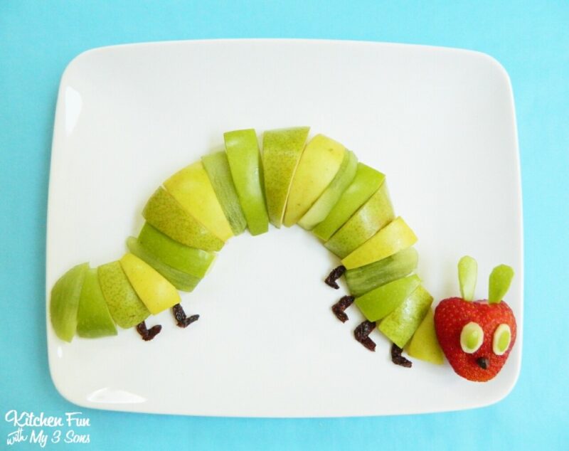 Green and red apple slices are put together to form a caterpillar.