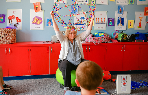 Teacher holding up an inflatable ball, as an example of sensory room ideas