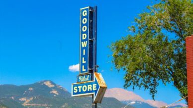Goodwill store sign with mountains in the background. Photo by Nosiuol on Unsplash. (Teacher Bargain Shopping Guide)
