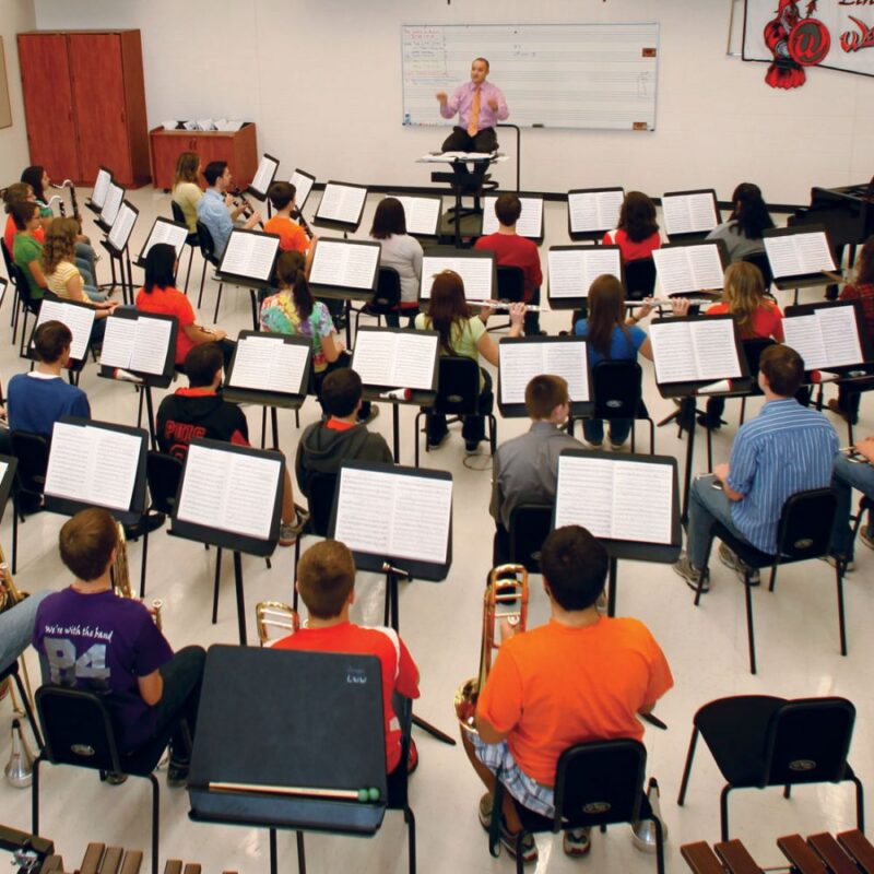 Classroom of students with music education products like instruments, chairs and music stands, seated in classroom with Bravo music stands in front of them