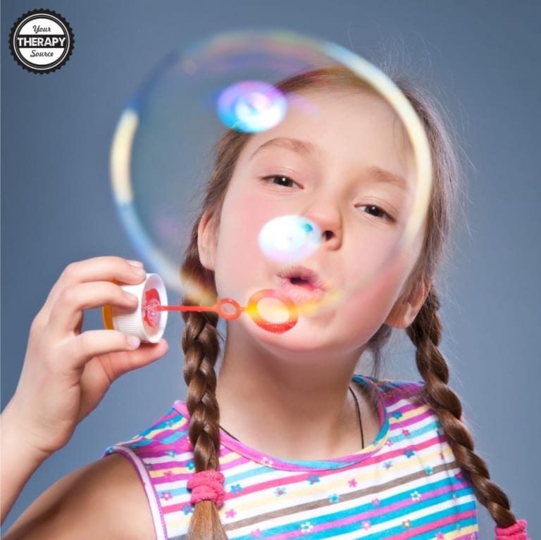 Girl with braids happily blowing a bubble