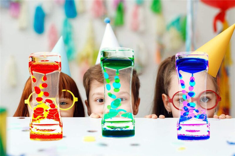 Three children stand behind bubble timers in red, green, and blue. They are similar to lava lamps. 