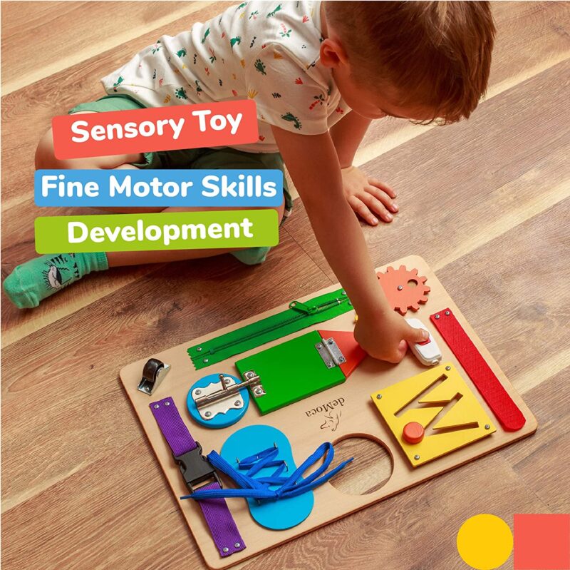 A small child plays with a wooden board that has different tasks like a shoelace to tie (sensory toys)