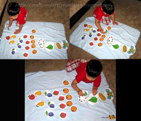 A little boy spreads food printables out on a white sheet. (very hungry caterpillar activities)