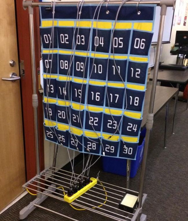Large numbered pocket chart with power strip and chargers to help manage cell phones in class