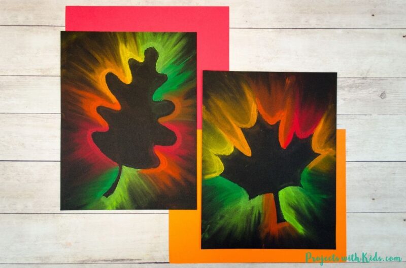 Fall art projects include this one on black paper with leaves on them.  The outer edge of the paper is decorated in neon chalk pastels.