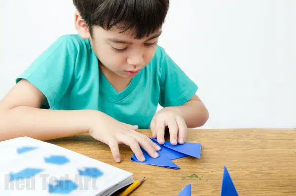 child making origami, as an example of indoor recess ideas