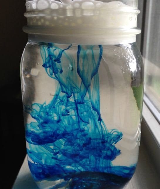 cloud in a jar experiment-mason jar willed with water and blue food coloring
