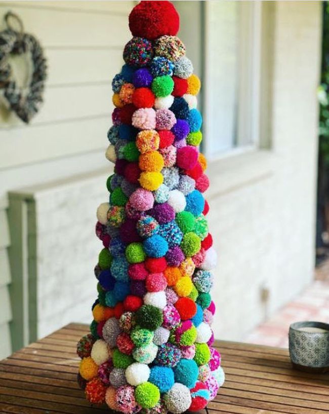 Small cone-shaped tree made from a variety of yarn pom poms