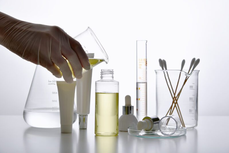 Dermatologist formulating and mixing pharmaceutical skincare, Cosmetic bottle containers and scientific glassware, Research and develop beauty product concept. - science careers