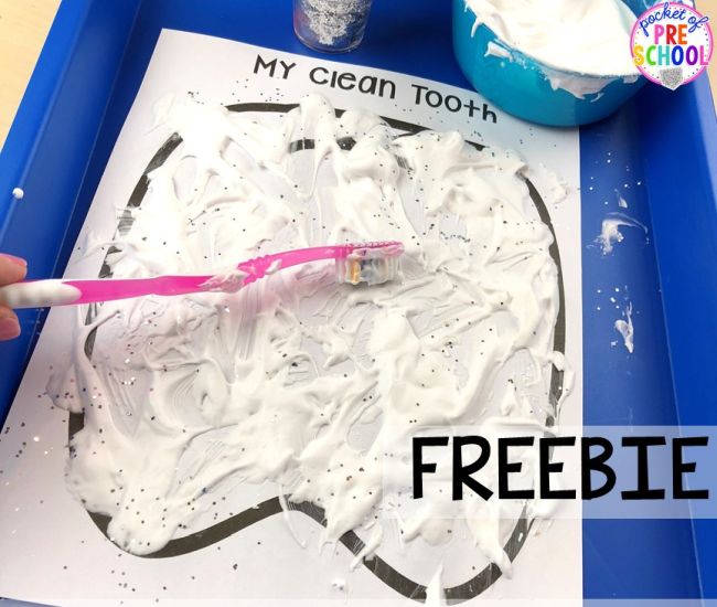 Student using a toothbrush to paint a paper tooth with paint made from shaving cream and glue (Dental Activities for Preschoolers)