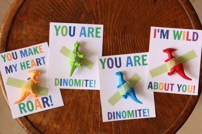 valentines with colorful mini dinosaur figurines taped to cards that say: "You are dinomite!", "You make my heart roar!", "I'm wild about you!"