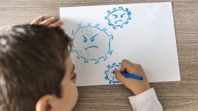 Young student drawing a germ in blue