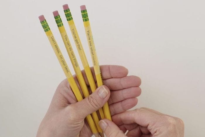 Teacher holding pencils personalized with clear tape (Dollar Store Hacks)