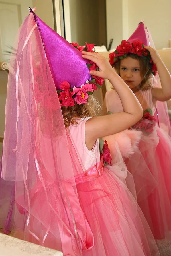 little girl dressed as a princess looking at herself in the mirror