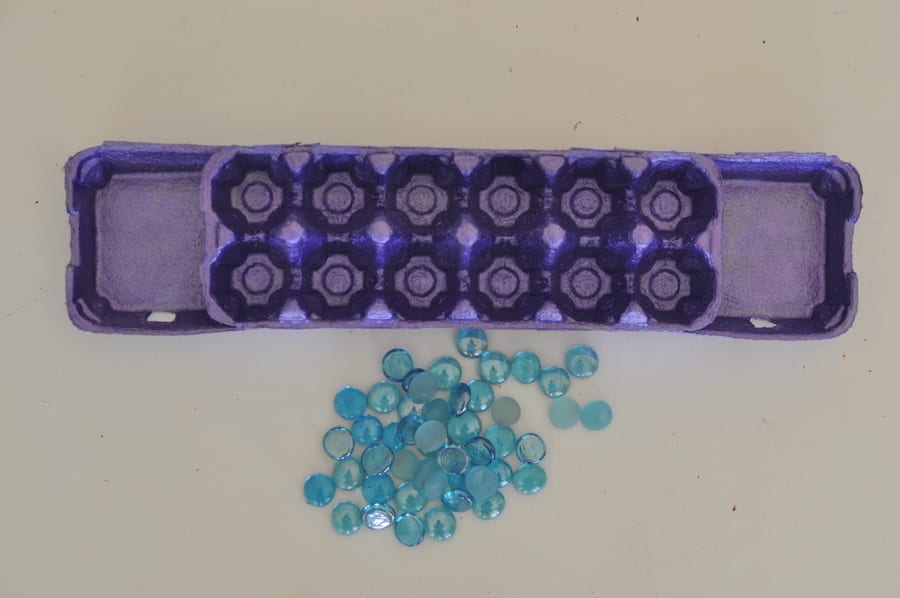 a colorful mancala set made from an egg carton and brightly colored jewels