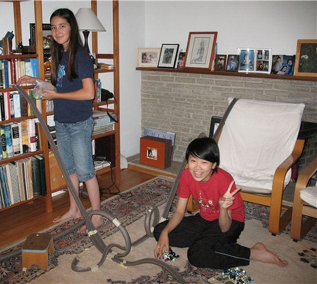 Two students building a marble roller coaster from foam insulation tubes