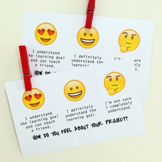 a notecard with emojis on it and clothespins for students to check for understanding