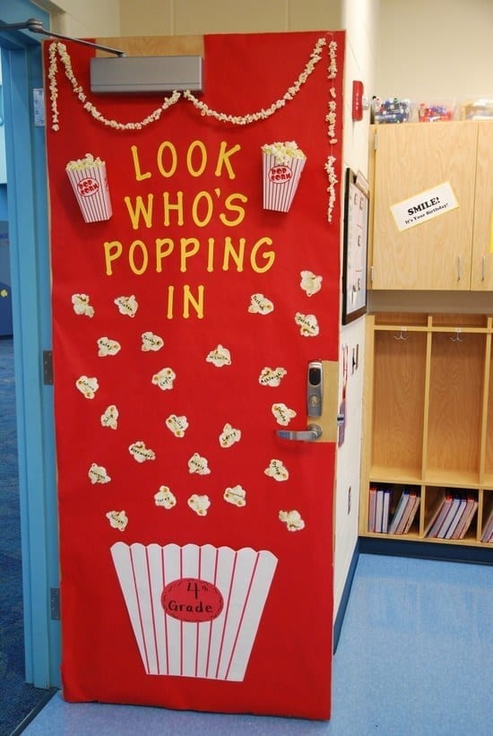 Door decoration of a bowl of popcorn spilling and the words "look who's popping in" -- classroom doors