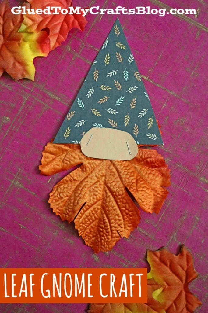 Bir şapka için karalama defteri kağıdından bir cüce ve sakal için bir sonbahar yaprağı yapılır ve aralarına bir burun zımbalanır.
