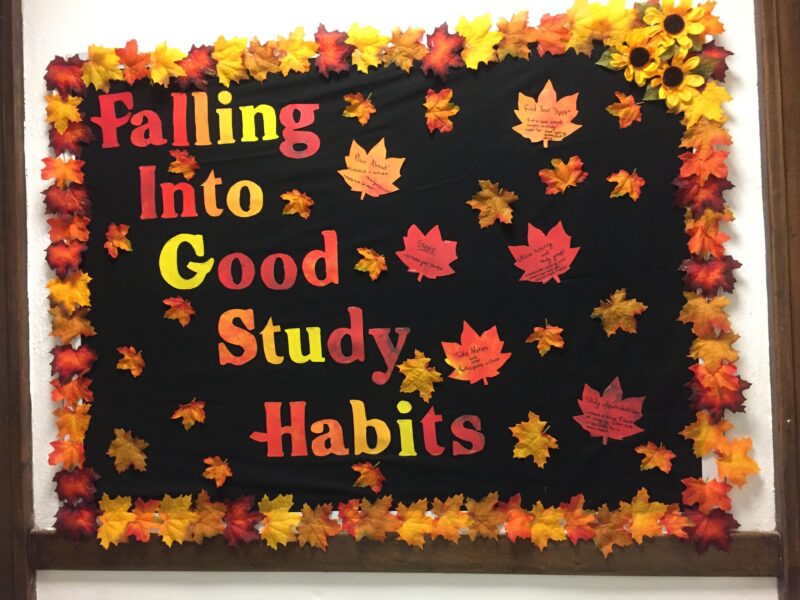 A black background has fall colored text that reads falling into good study habits. The black background is covered in leaves that have the habits listed on them.