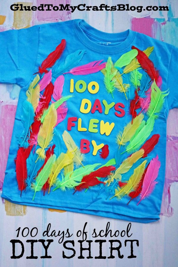قميص أزرق مخضر مزين بالريش الملون عليه وملصقات مكتوب عليها 100 Days Flew By (100 يوم من أفكار قميص المدرسة)